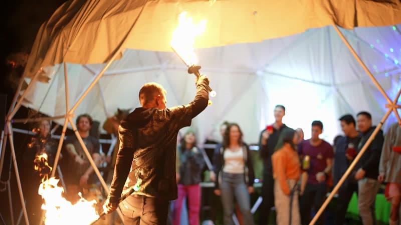 Fire performer in front of the dome with crowd watching